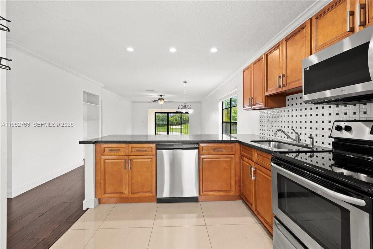 7944 Eastlake Drive, Unit D Boca Raton, FL 33433 - Photo 6 of 29 a kitchen with stainless steel appliances granite countertop a stove a sink and a microwave