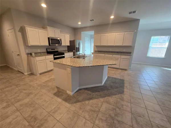 a large kitchen with kitchen island granite countertop a large counter top stainless steel appliances and cabinets