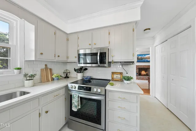 a dining room filled chandelier and kitchen view