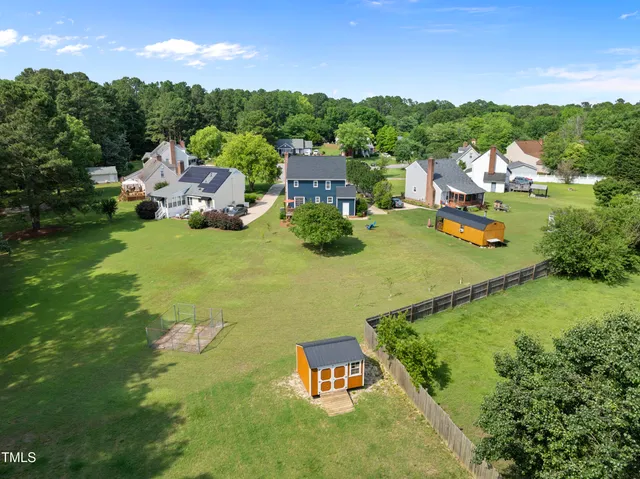an aerial view of a house with garden space and street view