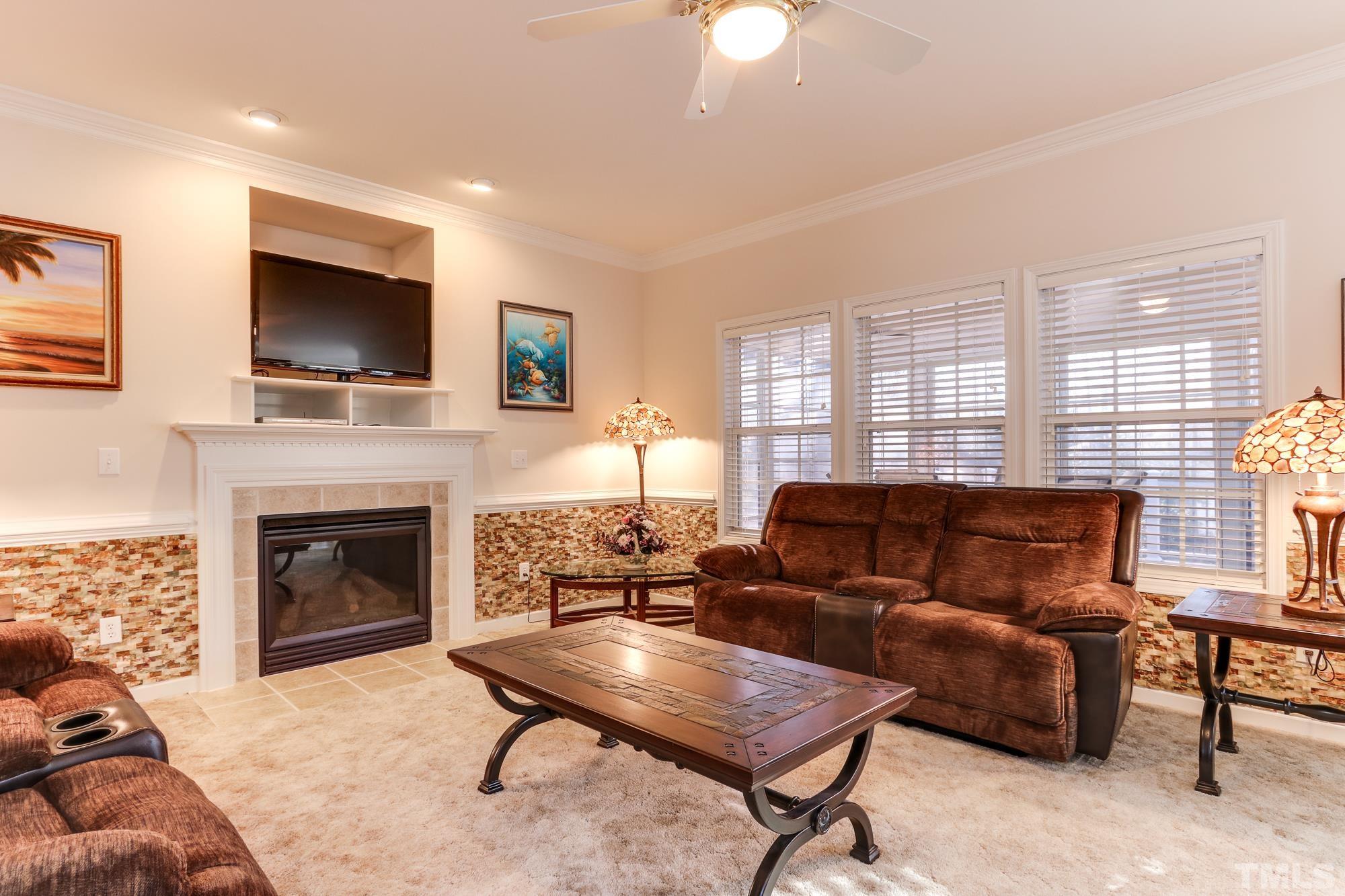 100 Mickleson Ridge Drive Raleigh, NC 27603 - Photo 11 of 59 a living room with furniture a flat screen tv and a fireplace