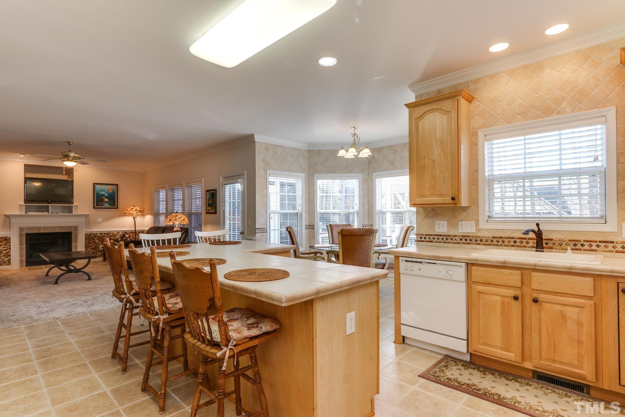 100 Mickleson Ridge Drive Raleigh, NC 27603 - Photo 16 of 59 a kitchen with stainless steel appliances a table chairs sink refrigerator and cabinets