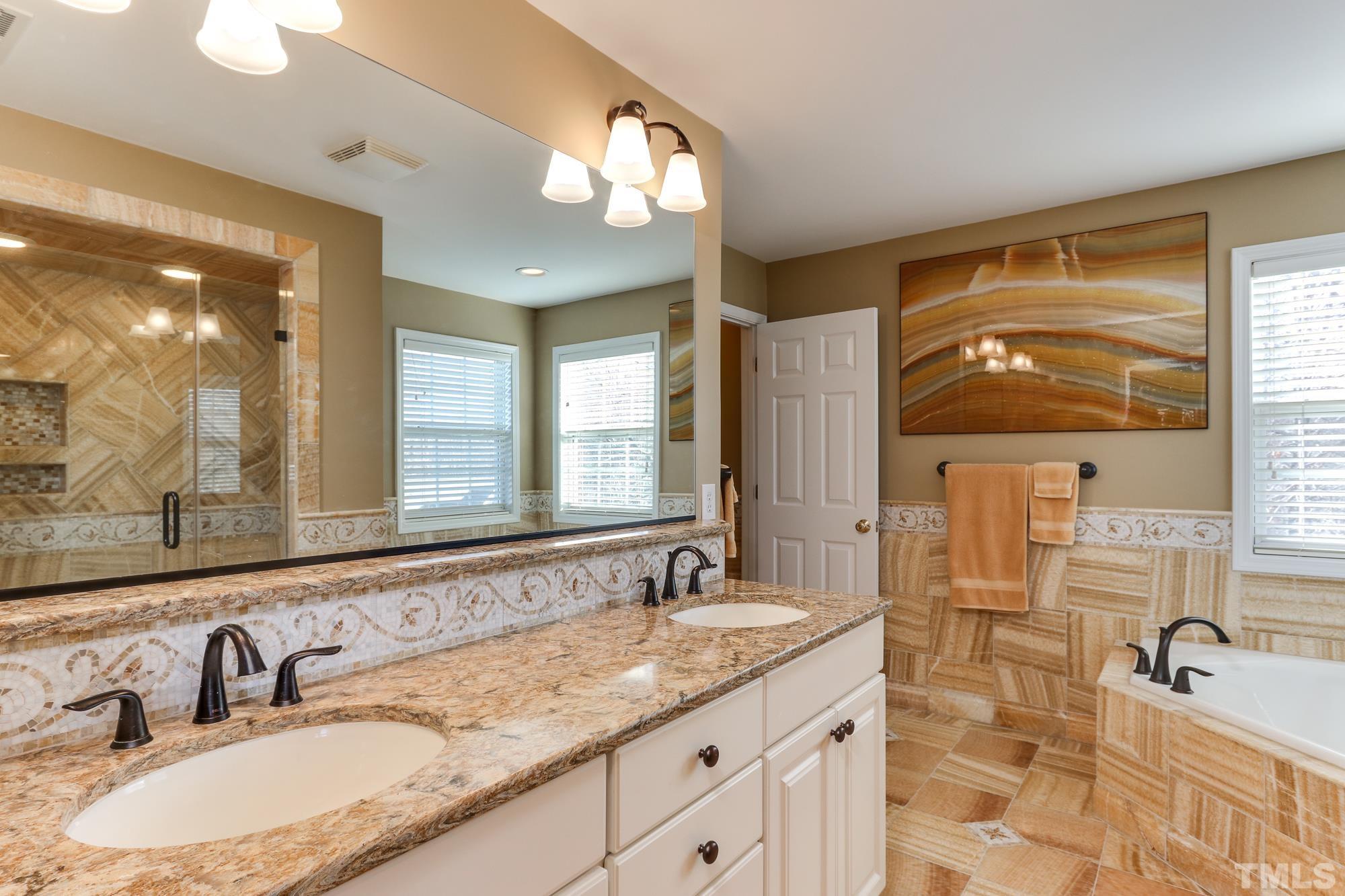 100 Mickleson Ridge Drive Raleigh, NC 27603 - Photo 24 of 59 a bathroom with double vanity sinks and a mirror