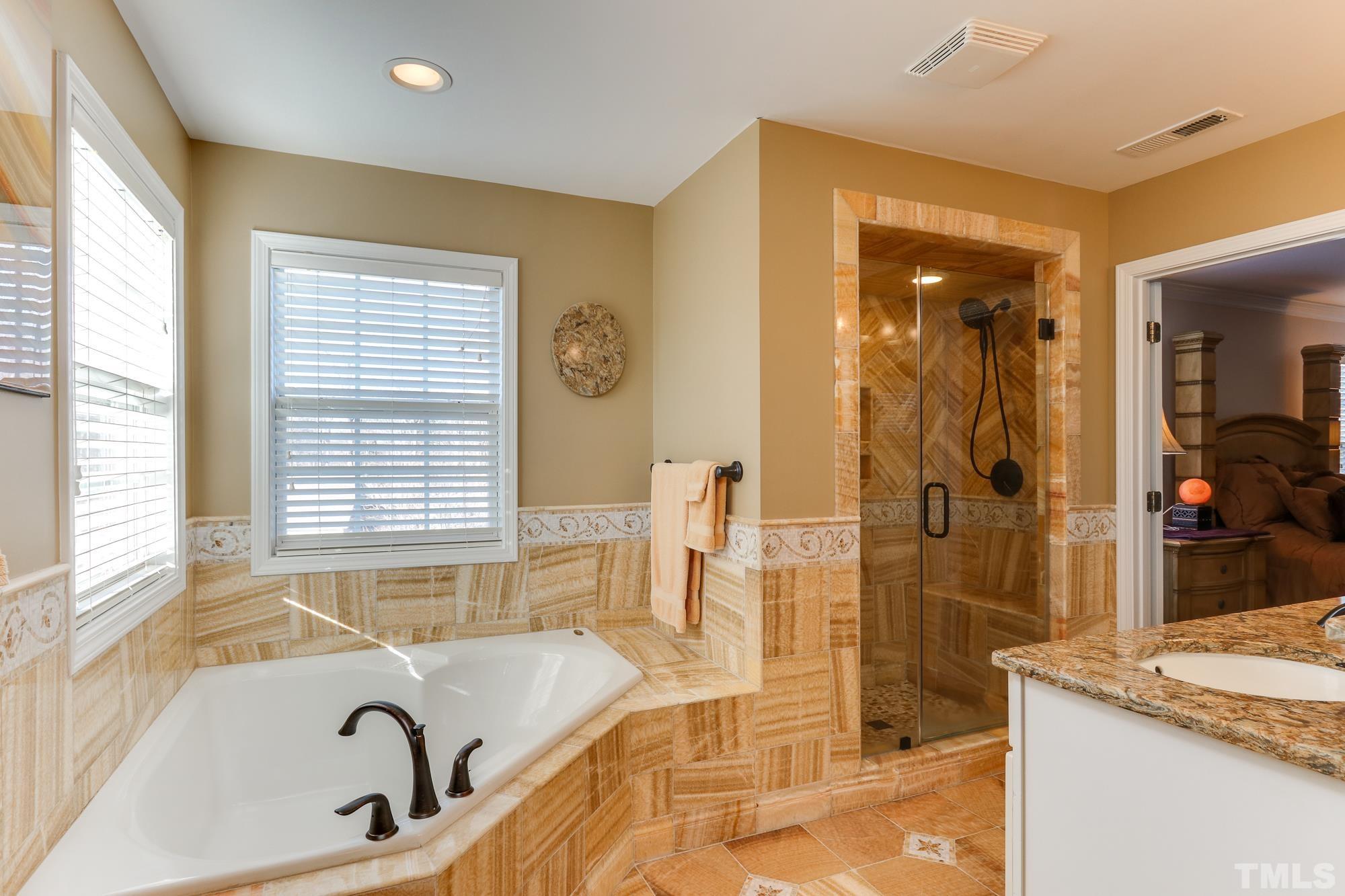 100 Mickleson Ridge Drive Raleigh, NC 27603 - Photo 25 of 59 a bathroom with a granite countertop tub and a sink
