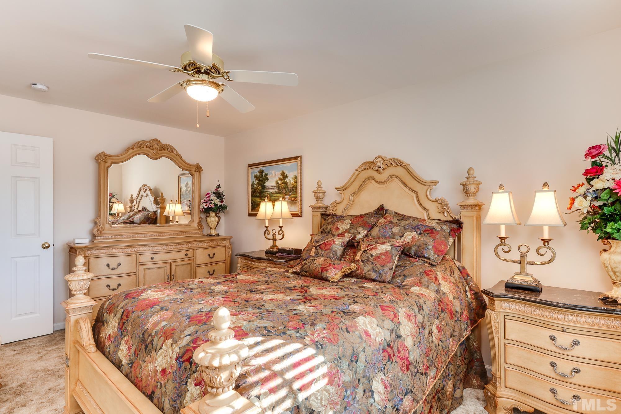 100 Mickleson Ridge Drive Raleigh, NC 27603 - Photo 29 of 59 a bed with a large bed and a chandelier