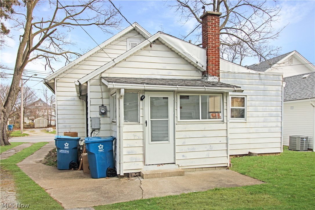407 Fremont Road Port Clinton, OH 43452 - Photo 16 of 22 Rear view of property with central air condition unit and a lawn