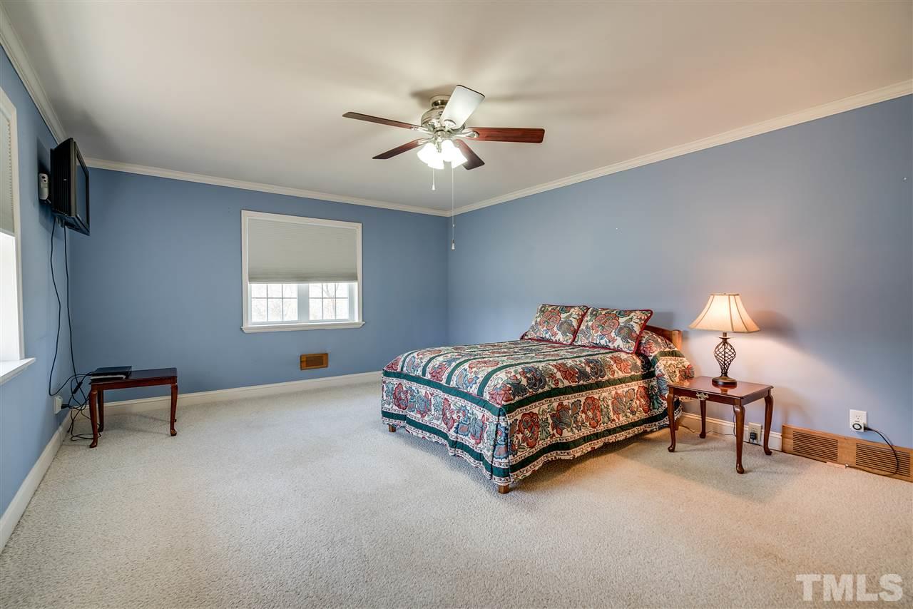 959 Lawson Chapel Church Road Roxboro, NC 27574 - Photo 16 of 25 a bedroom with a bed and a chandelier