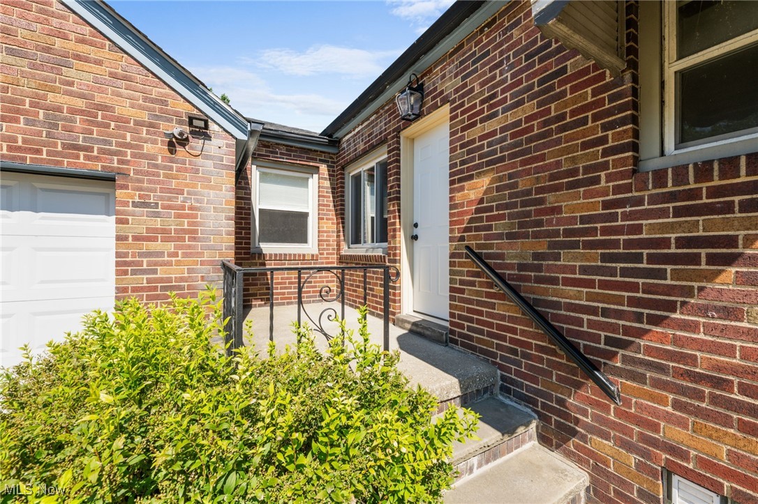 18122 Nottingham Road Cleveland, OH 44119 - Photo 28 of 29 View of exterior entry featuring brick siding and a garage