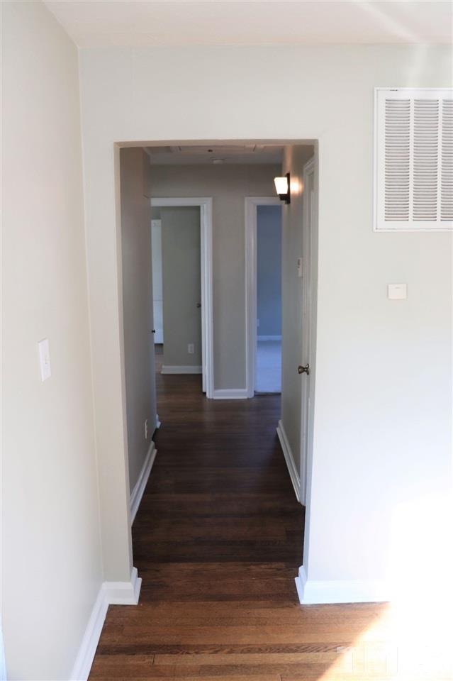 2110 Tudor Place Raleigh, NC 27610 - Photo 11 of 17 a view of a hallway with wooden floor and staircase