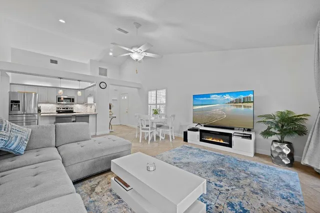 a living room with furniture a dining table with kitchen view