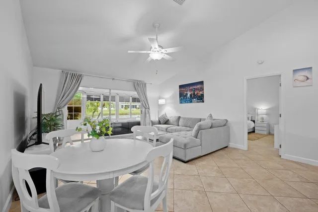 a living room with furniture potted plant and a large window