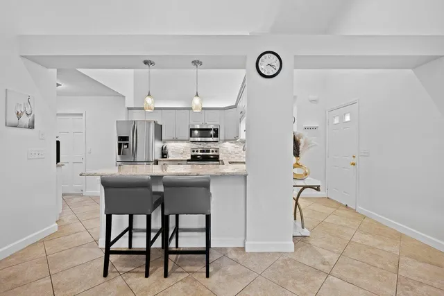 a kitchen with stainless steel appliances kitchen island granite countertop a table and chairs in it