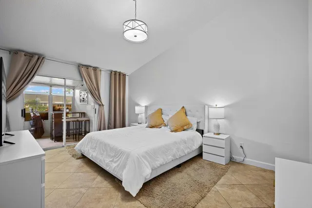 a bedroom with a large bed and a chandelier