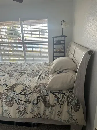 a bed sitting in a bedroom next to a window