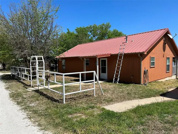 a view of a house with a yard and wooden fence