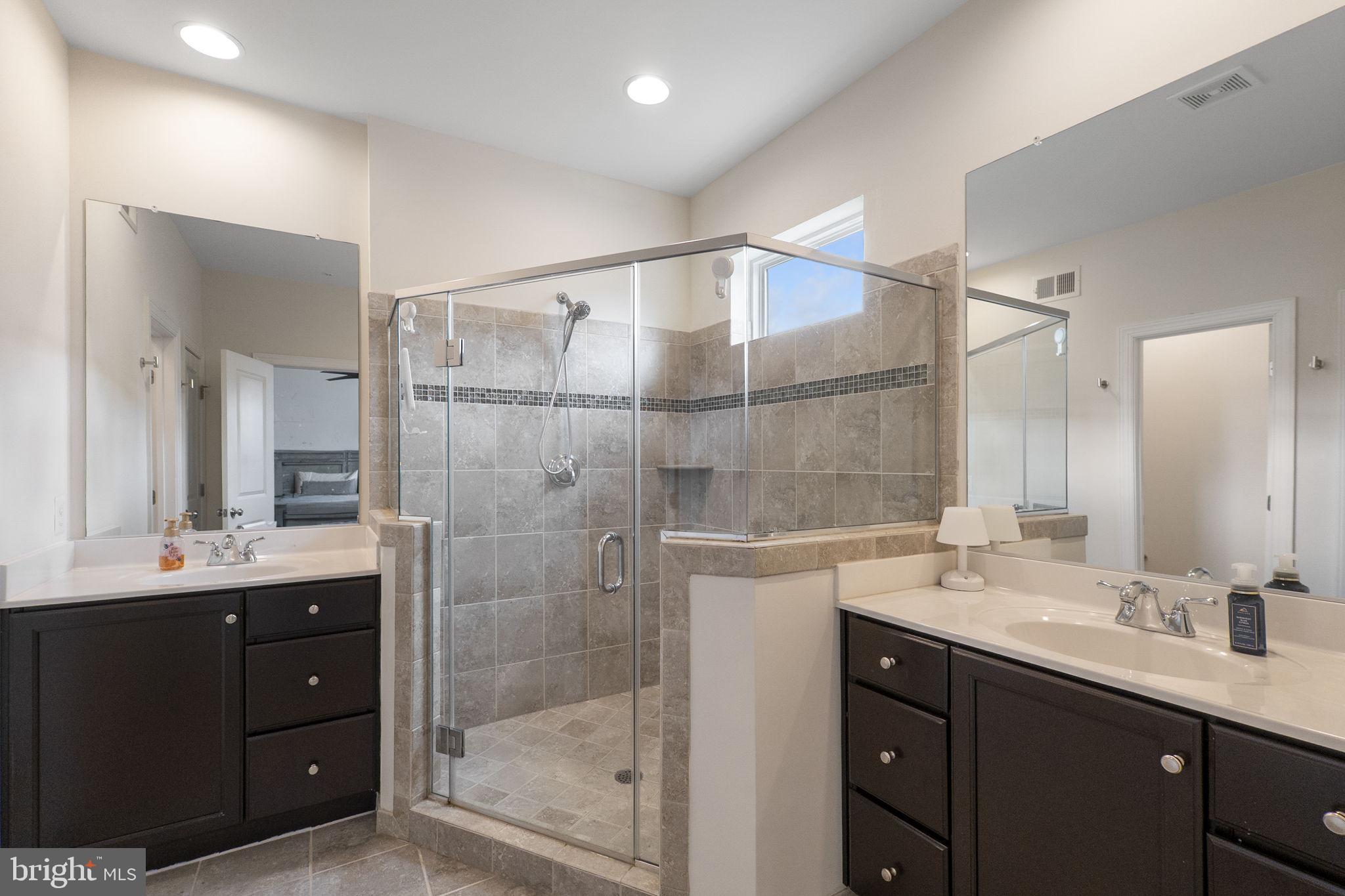 23902 Grapevine Ridge Terrace Clarksburg, MD 20871 - Photo 18 of 44 a bathroom with a double vanity sink mirror and shower