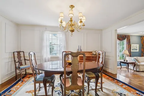 a view of a dining room with furniture a chandelier and wooden floor