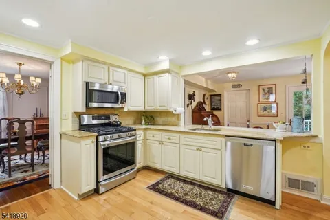 a kitchen with granite countertop white cabinets and appliances