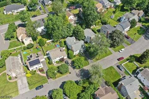 an aerial view of a house with a yard and lake view in back