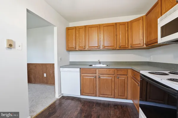 a kitchen with granite countertop wooden cabinets and a stove top oven