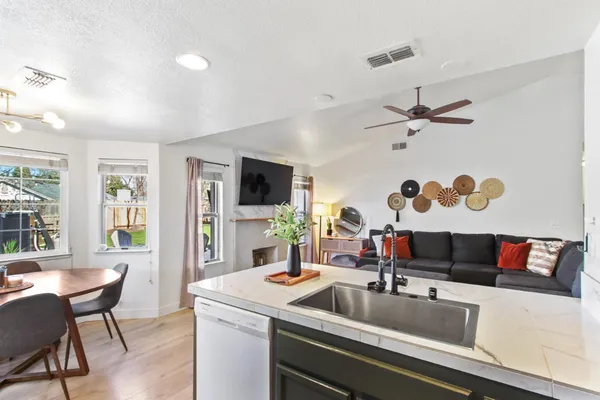 a kitchen with a sink and a stove with wooden floor