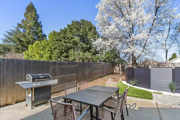 a backyard of a house with table and chairs