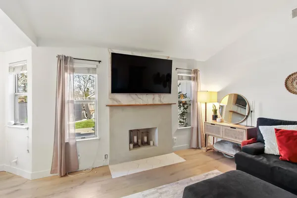 a living room with furniture a flat screen tv and a fireplace