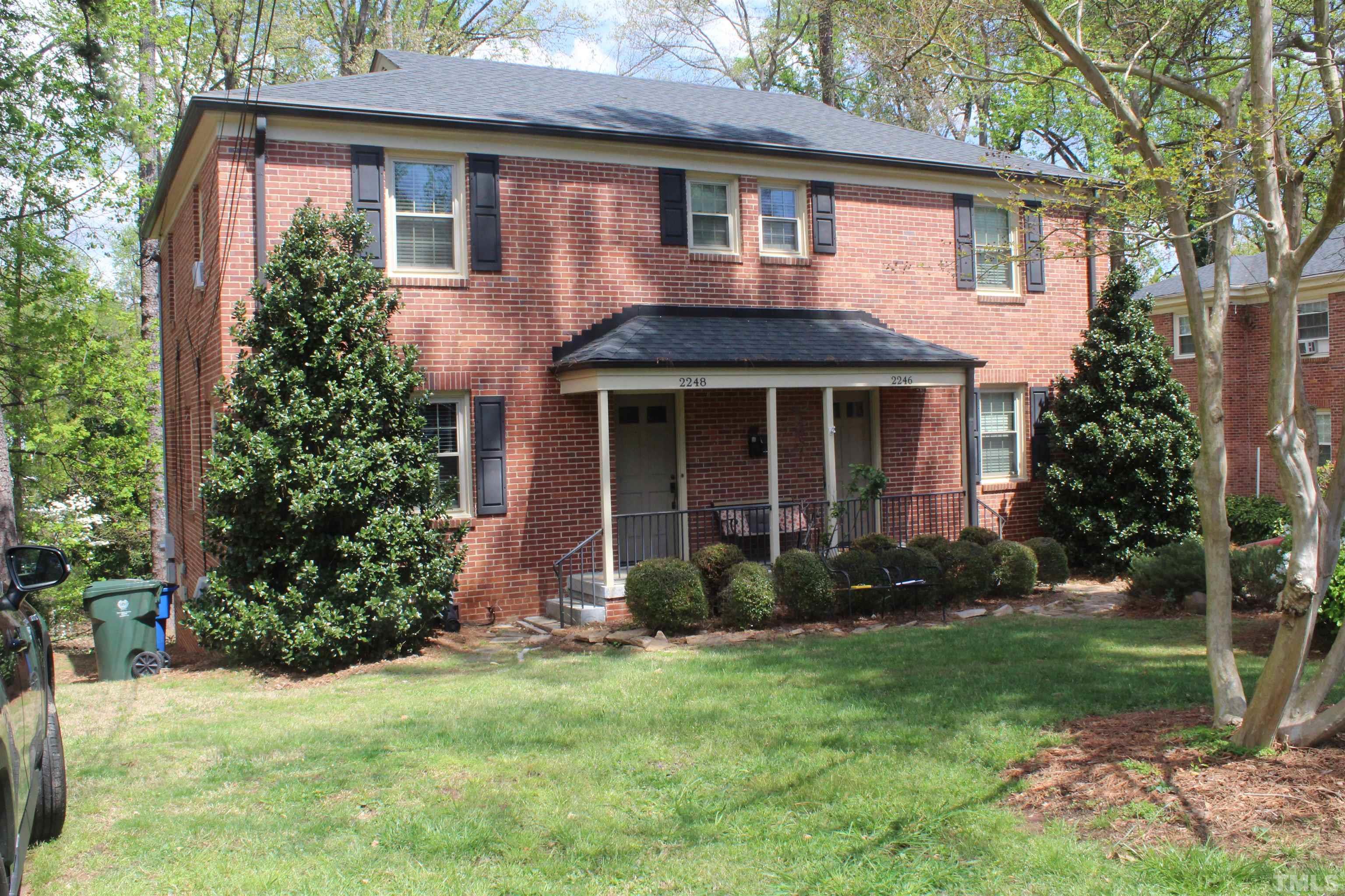 2248 The Circle, Unit 2 Raleigh, NC 27608 - Photo 1 of 21 a view of a brick house with a yard and large trees