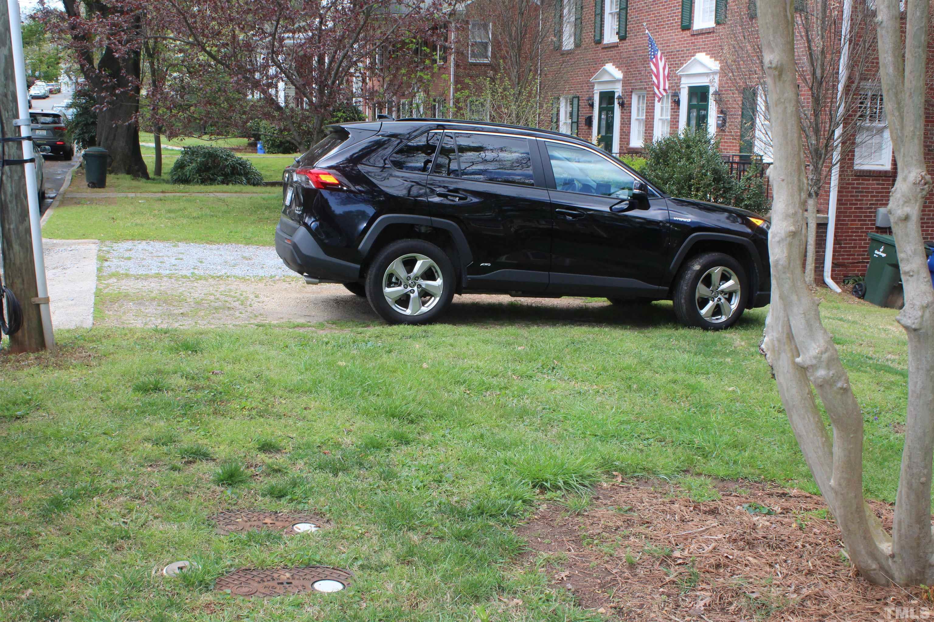 2248 The Circle, Unit 2 Raleigh, NC 27608 - Photo 21 of 21 a car parked in front of a house with a yard
