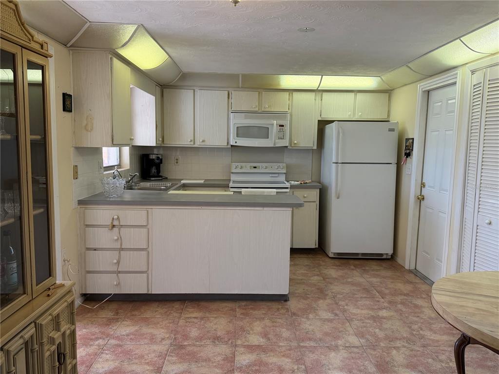 3914 Carioca Road Holiday, FL 34691 - Photo 9 of 23 a kitchen with a refrigerator sink and cabinets