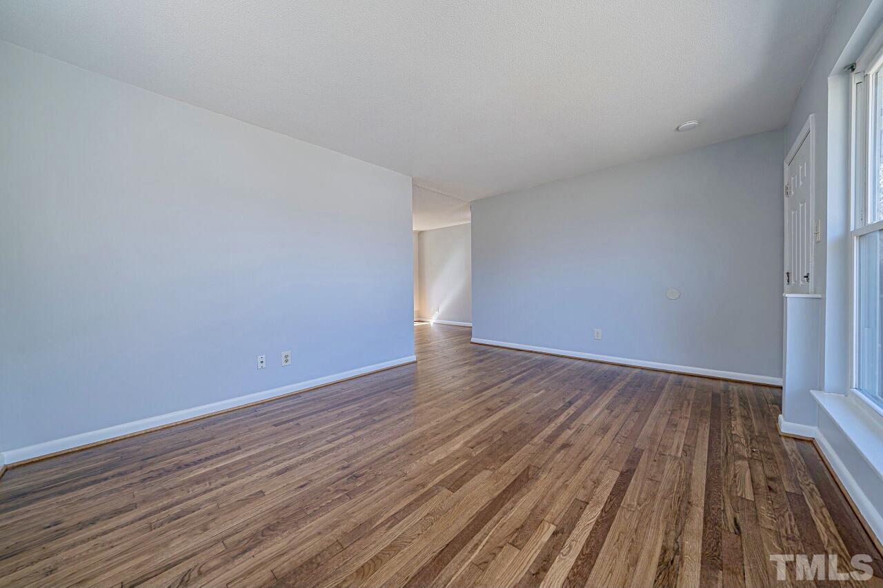 828 Newcombe Road Raleigh, NC 27610 - Photo 11 of 24 a view of an empty room with wooden floor