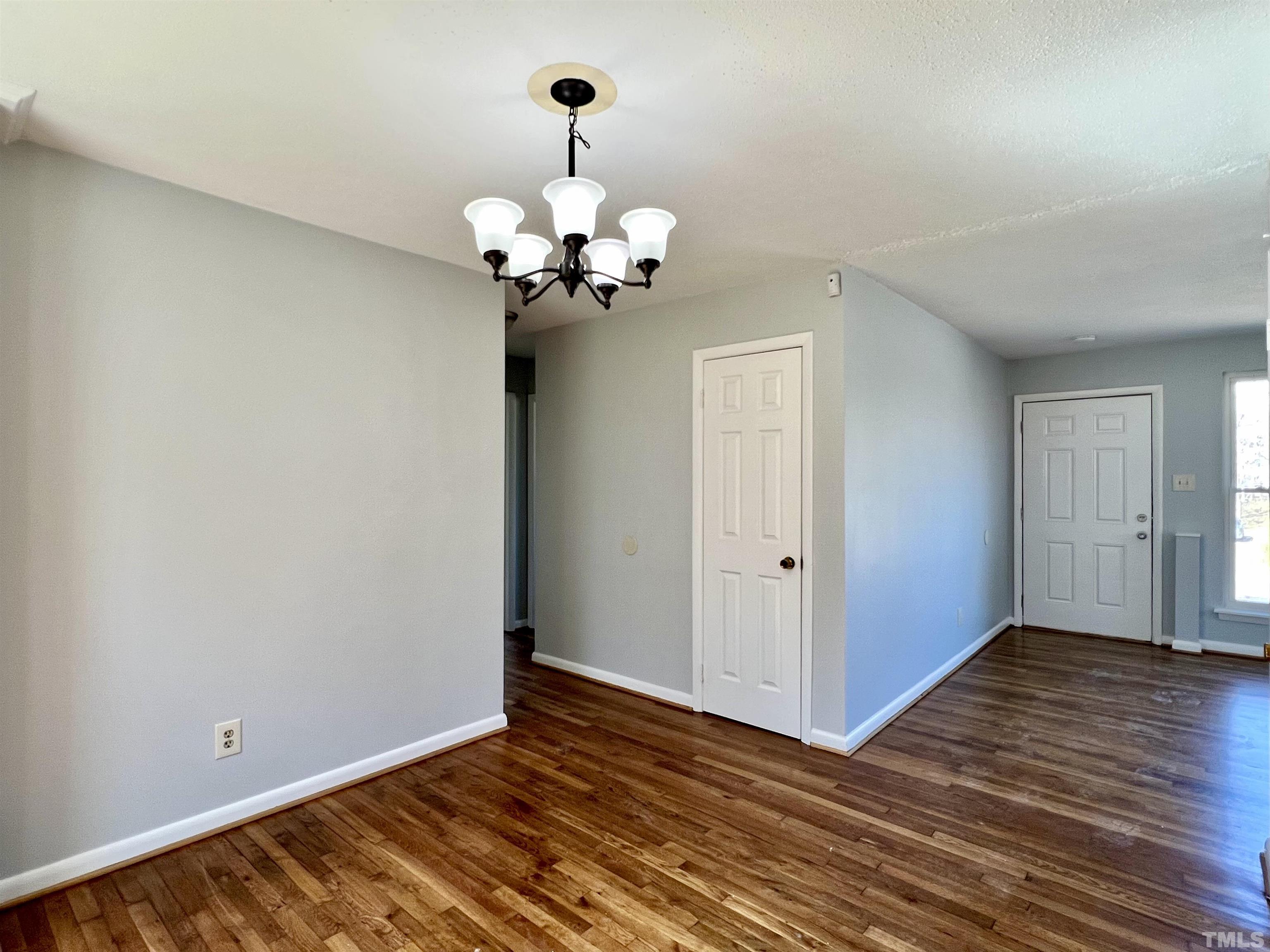 828 Newcombe Road Raleigh, NC 27610 - Photo 16 of 24 a view of an empty room with wooden floor and a window