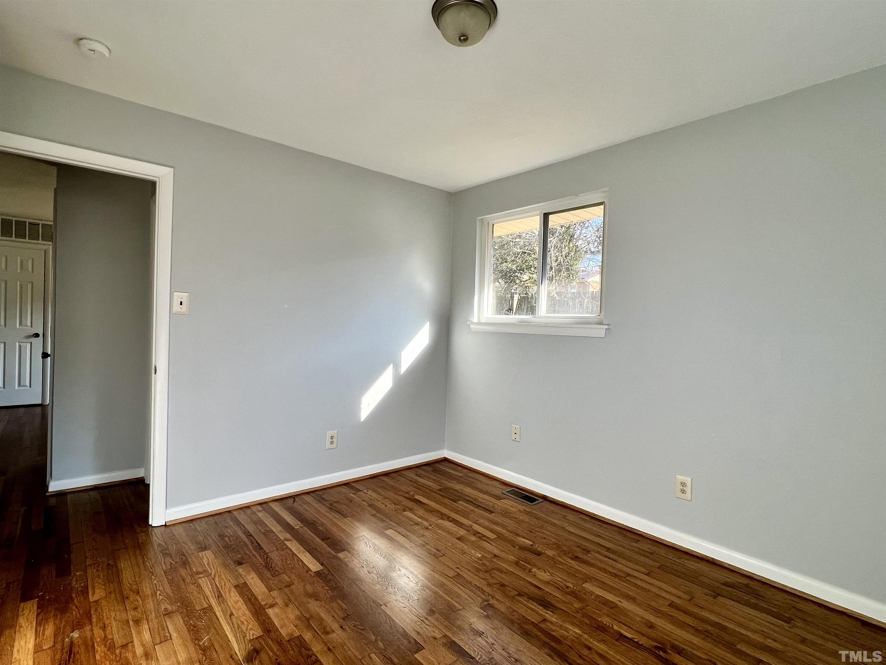 828 Newcombe Road Raleigh, NC 27610 - Photo 22 of 24 an empty room with wooden floor and windows