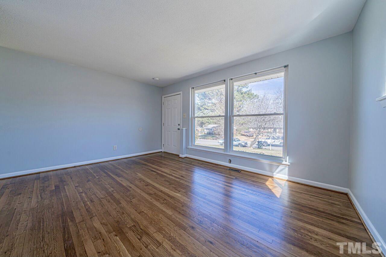 828 Newcombe Road Raleigh, NC 27610 - Photo 9 of 24 an empty room with wooden floor and windows