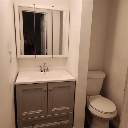 a bathroom with a toilet sink and mirror