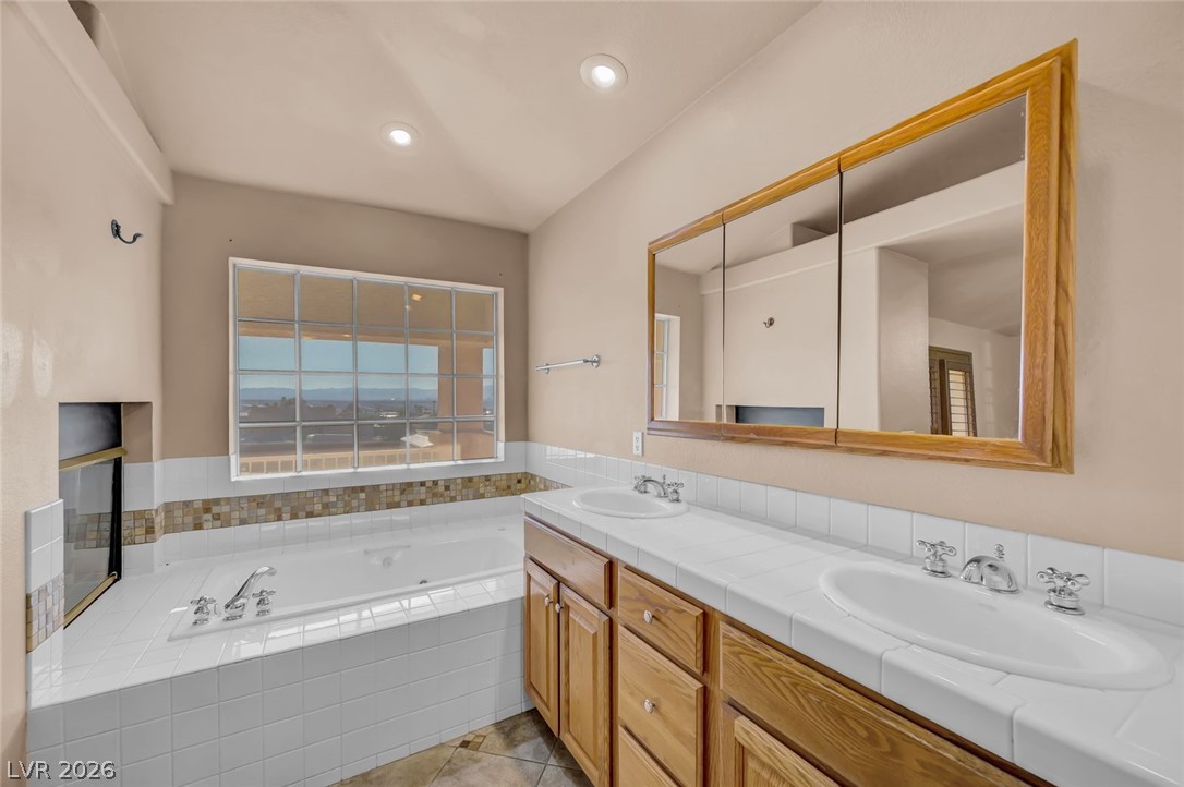 640 North Racetrack Road Henderson, NV 89015 - Photo 45 of 65 Indulge in a primary bathroom featuring a spacious soaking tub and dual vanities, perfect for unwinding.