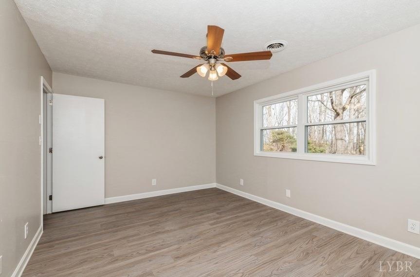1180 David Giles Lane Blairs, VA 24527 - Photo 19 of 34 an empty room with wooden floor chandelier fan and windows