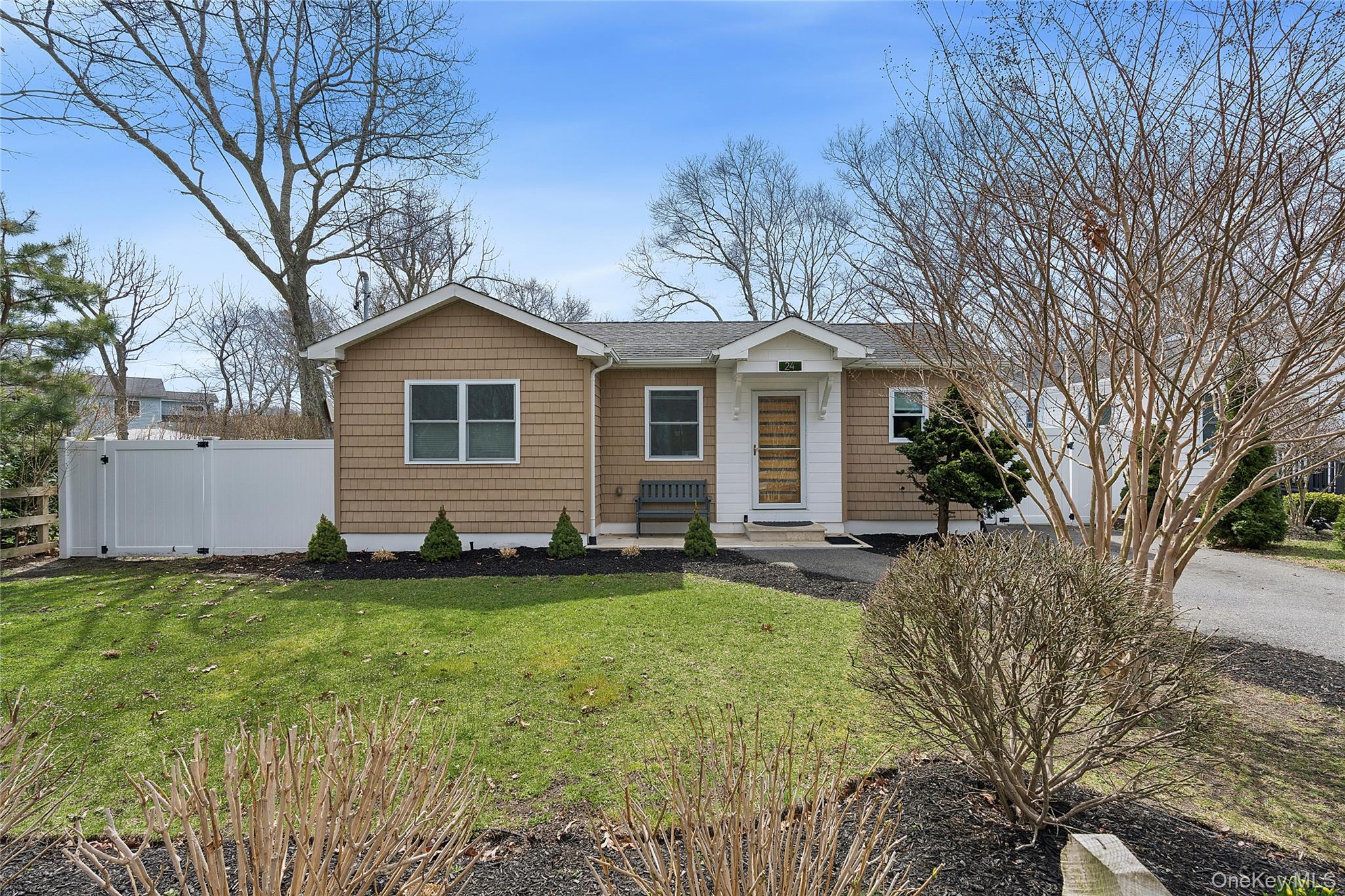 24 Woodridge Road Hampton Bays, NY 11946 - Photo 4 of 18 a front view of a house with a yard