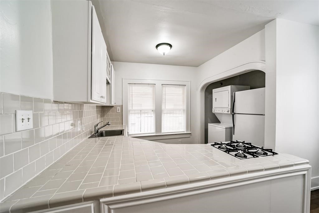 2235 Welch Street Houston, TX 77019 - Photo 6 of 18 a kitchen with a stove a sink and a refrigerator