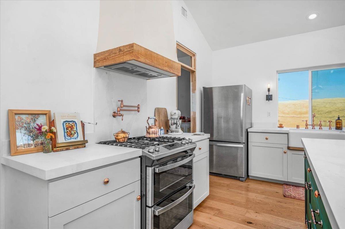 22654 Cobblestone Lane Sanger, CA 93657 - Photo 23 of 64 a kitchen with stainless steel appliances white cabinets and wooden floor