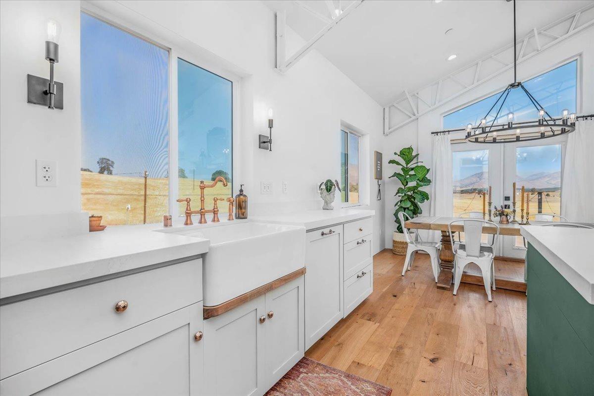 22654 Cobblestone Lane Sanger, CA 93657 - Photo 25 of 64 a kitchen with a sink dishwasher a dining table and chairs with wooden floor