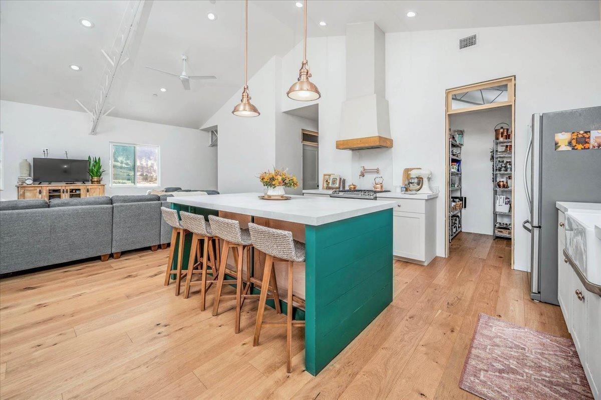 22654 Cobblestone Lane Sanger, CA 93657 - Photo 26 of 64 a kitchen with stainless steel appliances kitchen island granite countertop a table chairs sink and cabinets