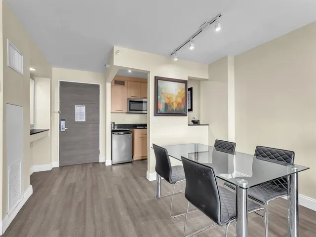 a kitchen with a table chairs refrigerator and microwave
