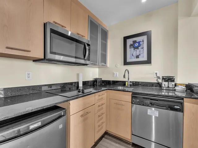 a kitchen with stainless steel appliances granite countertop a sink and a stove