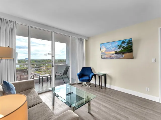 a living room with furniture and floor to ceiling windows