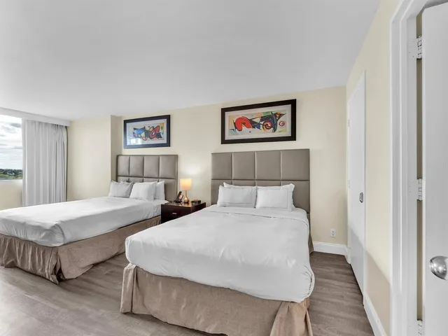 a bedroom with two beds and a painting on the wall