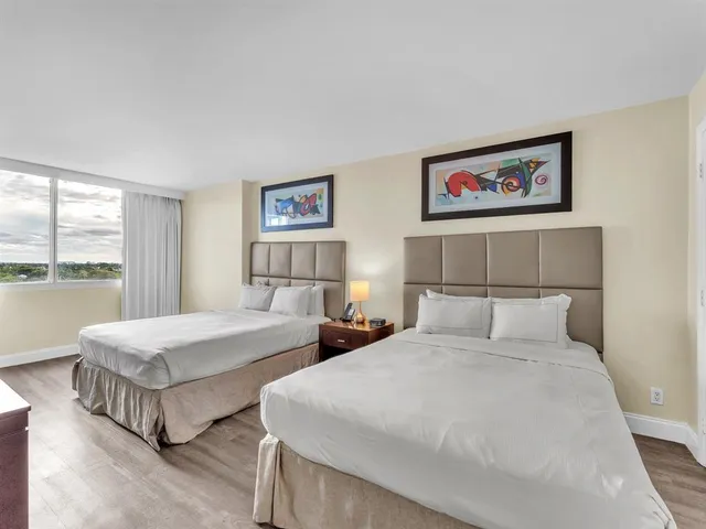 a bedroom with two beds and a large window