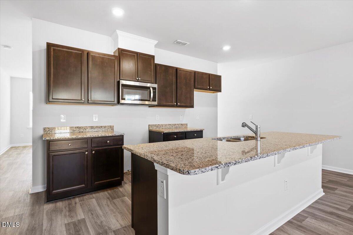 1387 Hasse Avenue Apex, NC 27502 - Photo 10 of 27 a kitchen with stainless steel appliances granite countertop a sink stove and microwave