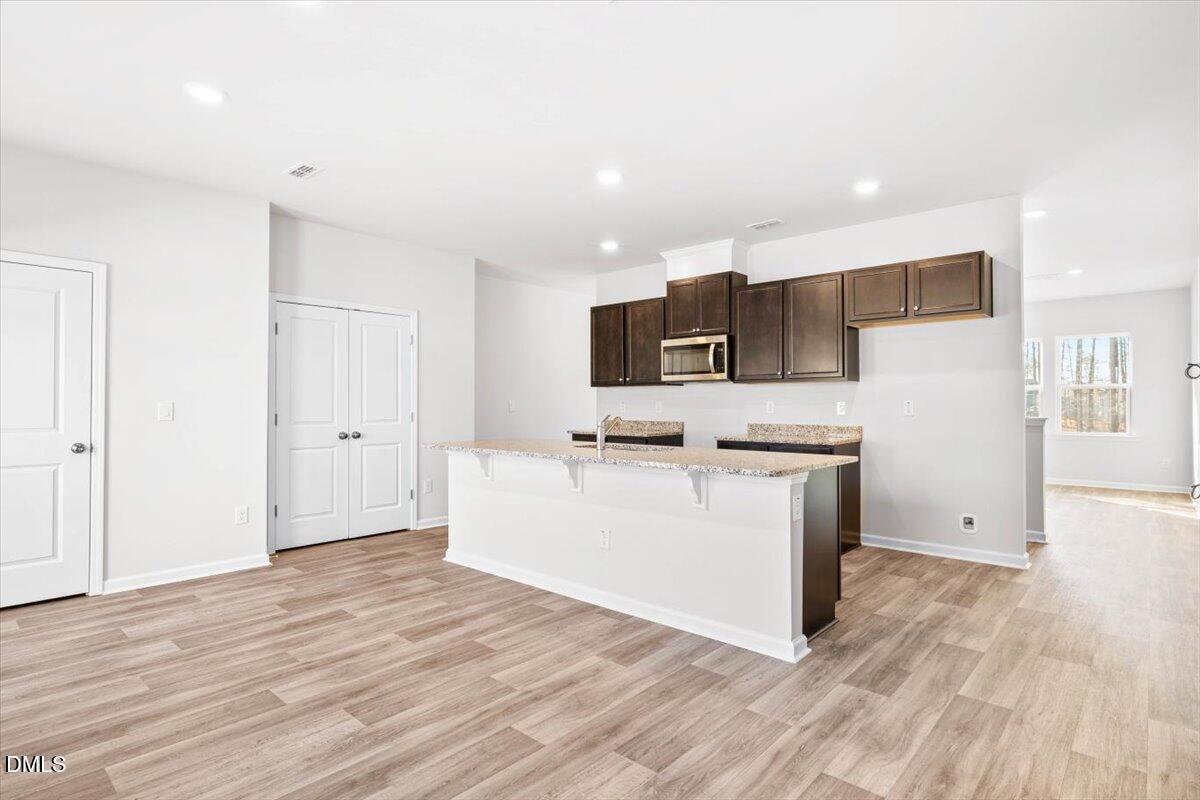 1387 Hasse Avenue Apex, NC 27502 - Photo 11 of 27 a view of kitchen with stainless steel appliances wooden floor and large window