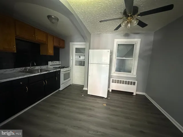 a kitchen with a refrigerator a stove top oven a sink and dishwasher